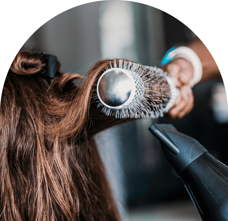 Hair being styled with brush and dryer.